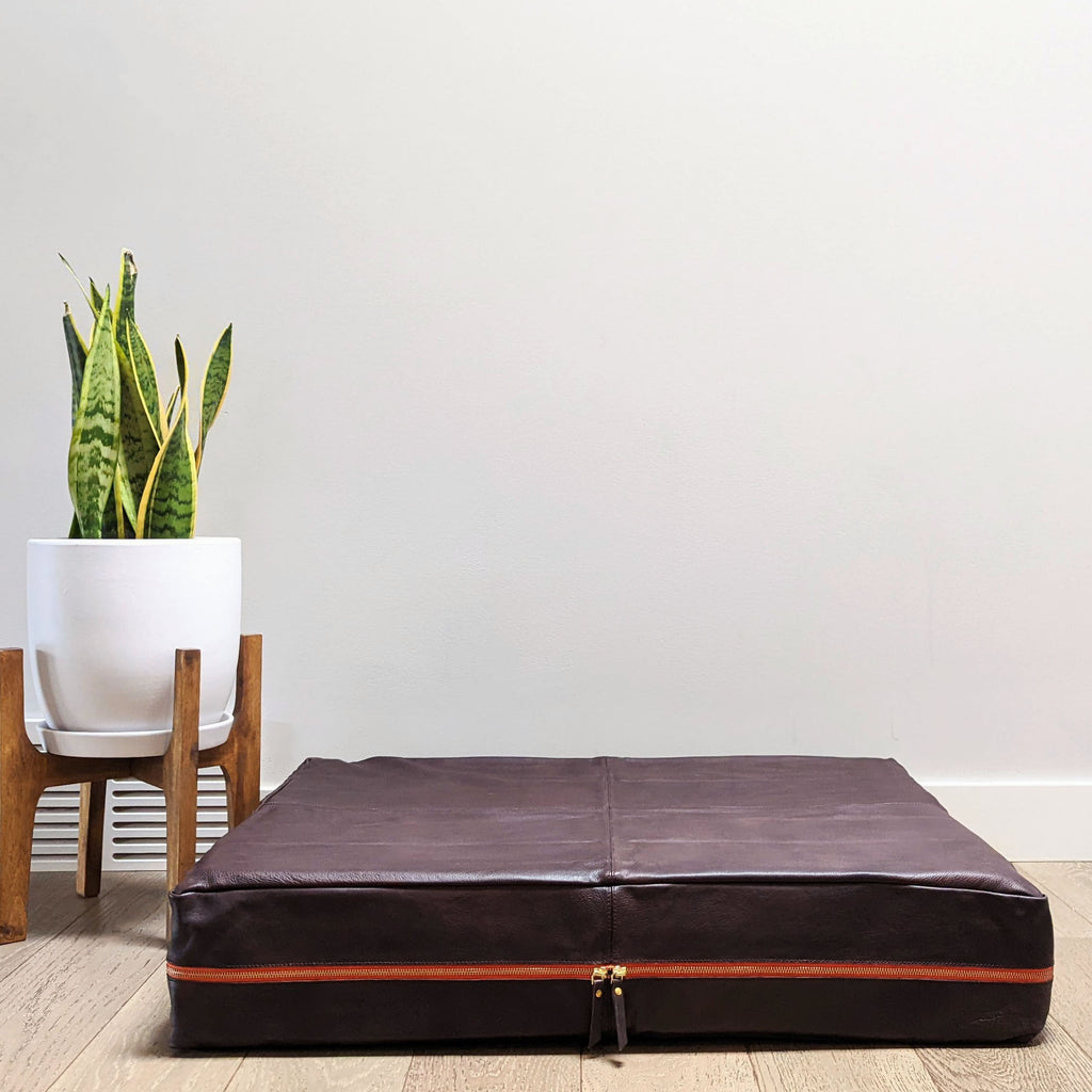 Le Bed Chocolate Brown leather dog bed. Back zipper detail in Le Dog signature orange. The best dog bed to support your dog with a dual foam orthopaedic mattress.